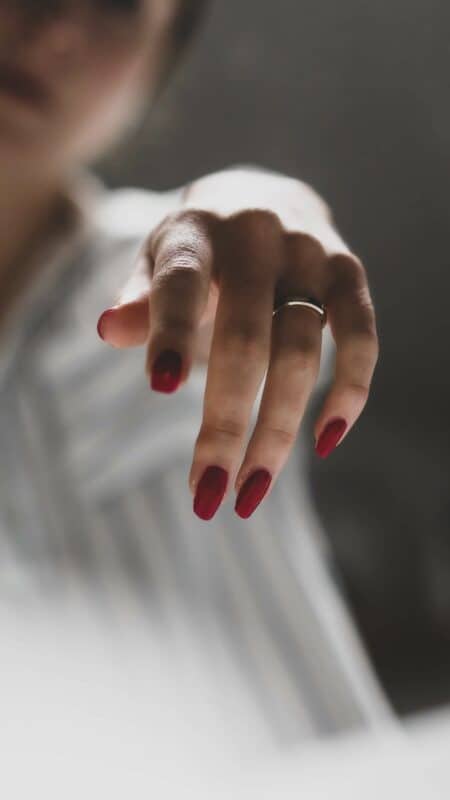 qu'est ce que le vernis naturel : mains de femme avec du vernis rouge