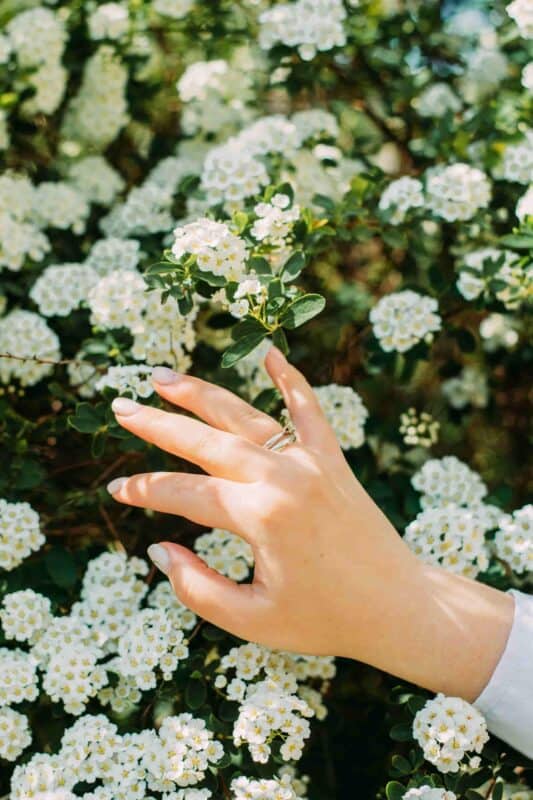 qu'est ce qu'une manucure : femme avec la main dans les fleurs