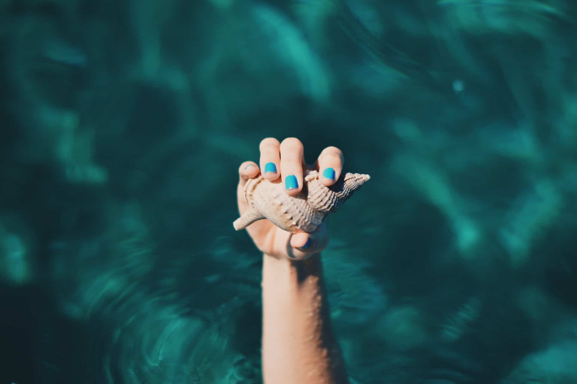 avantages et inconvénients du vernis semi permanent : femme qui tient un coquillage dans ses mains