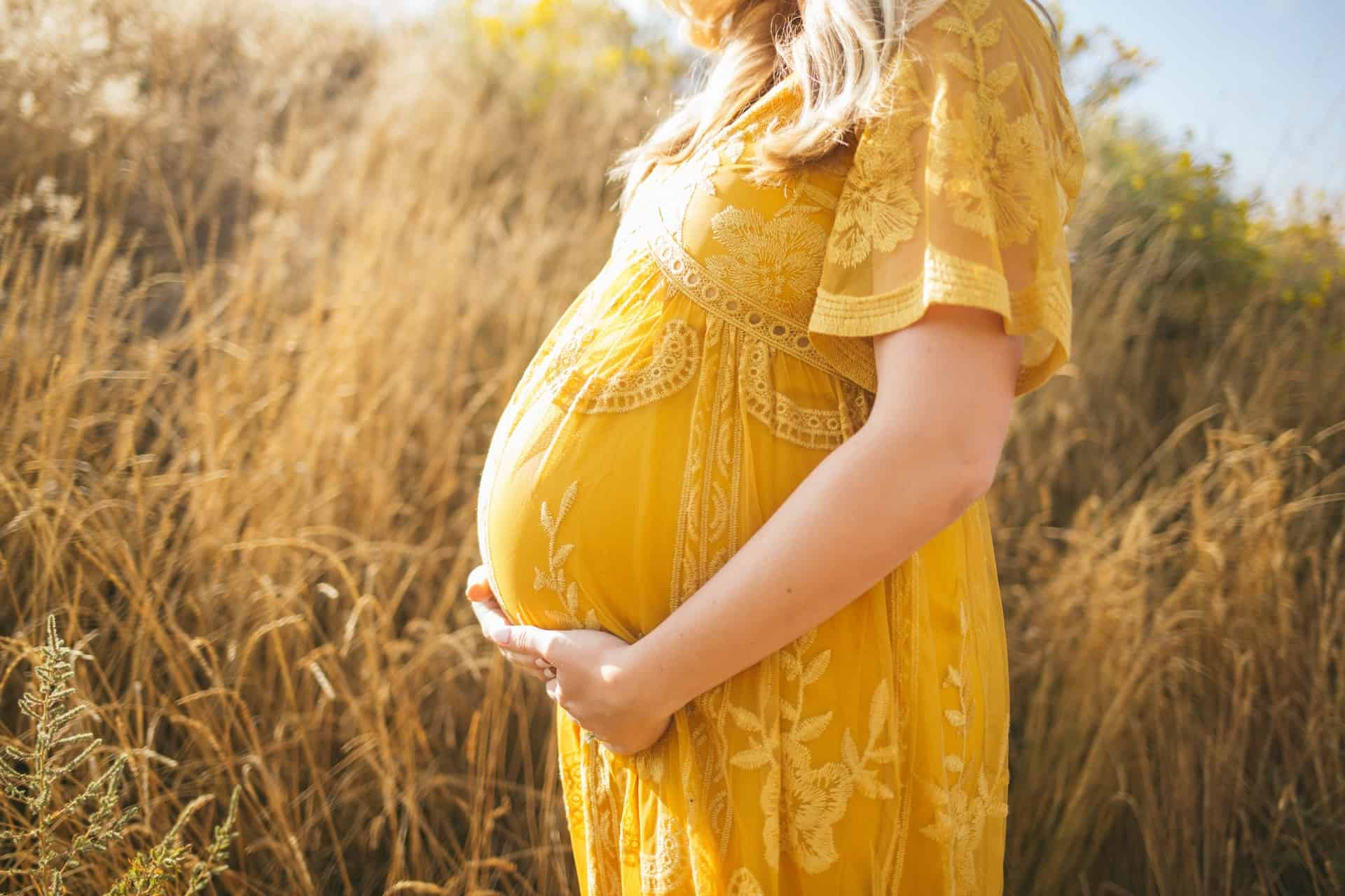 vernis semi permanent grossesse : femme enceinte dans un champs