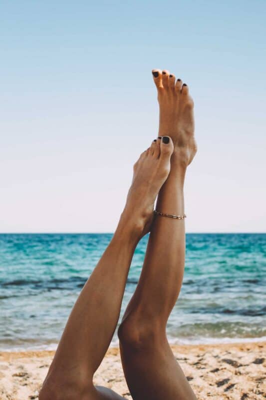 bienfaits pédicure : jambes d'une femme à la plage