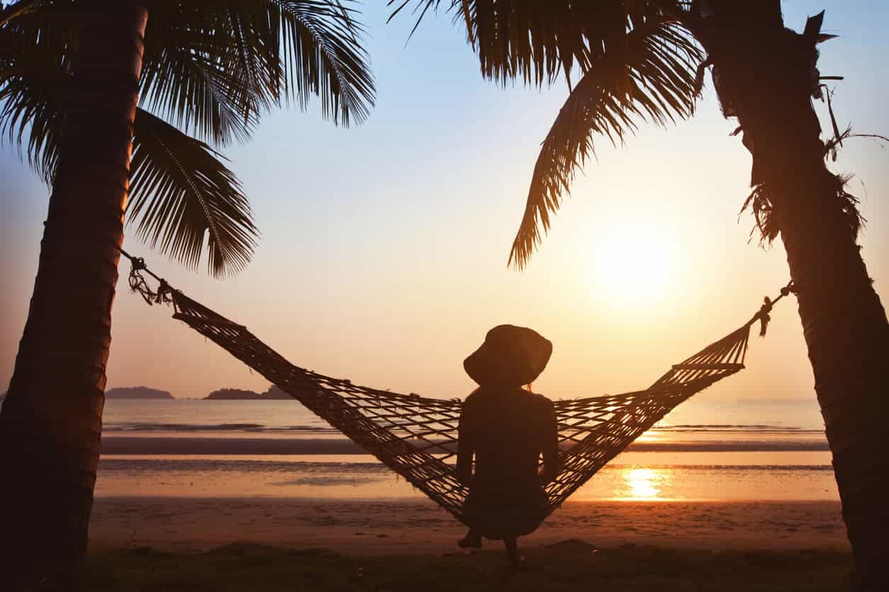 gommage et bronzage : femme sur un hamac à la plage