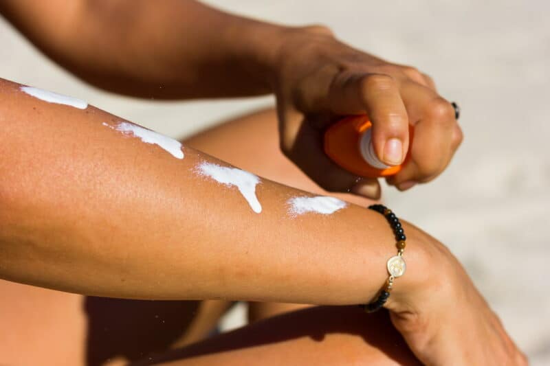 protéger sa peau du soleil : femme qui applique de la crème solaire sur son bras
