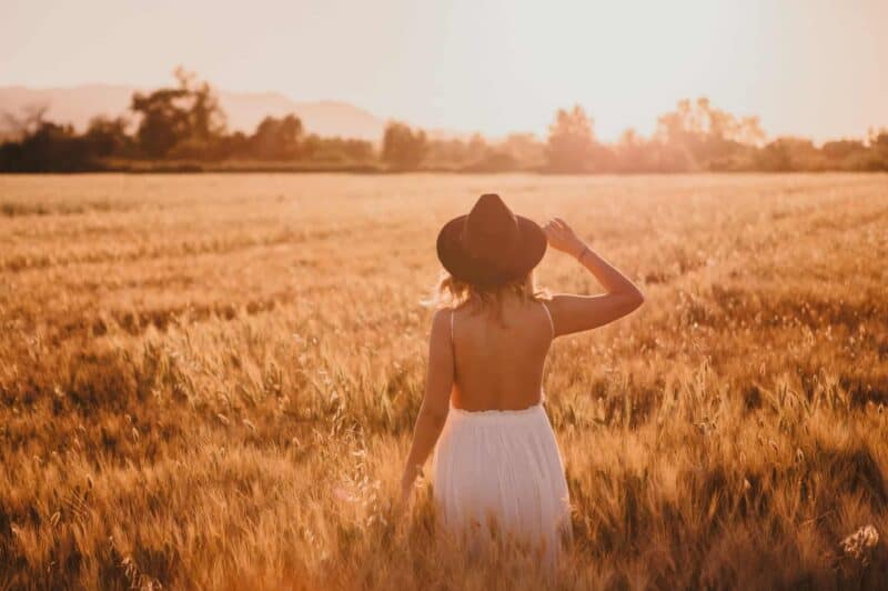 bienfaits du soleil : femme dans un champs avec un chapeau