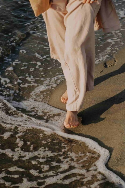 eau de mer et cheveux : femme à la plage qui met les pieds dans l'eau