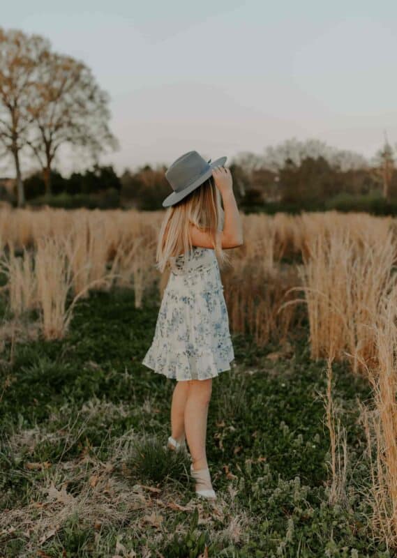 proteger mes cheveux du soleil : femme dans un champ avec une robe et un chapeau