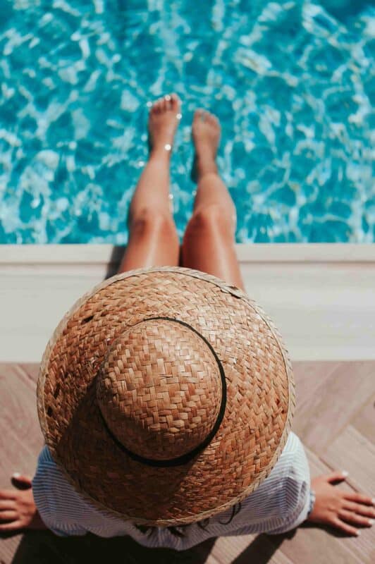 qu'est ce que le spf : femme avec un chapeau au bord de la piscine