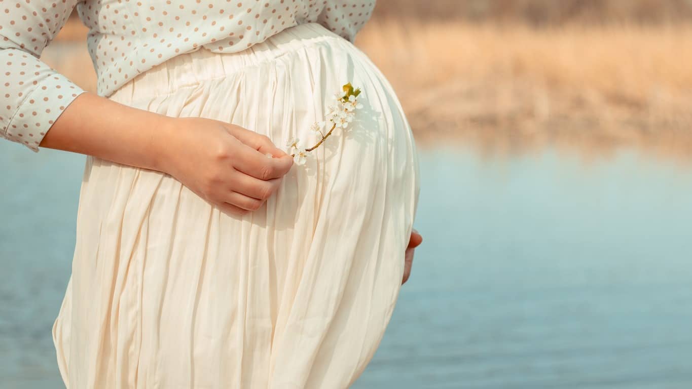 démangeaisons ventre grossesse : femme enceinte au bord d'un lac