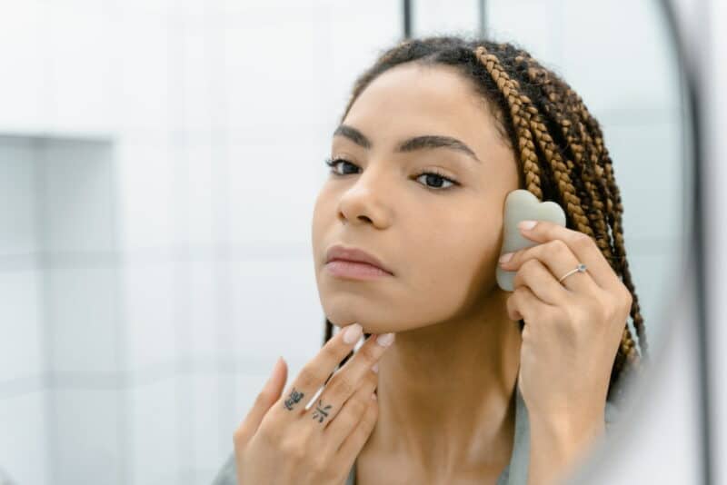 auto massage visage : une femme fait un massage gua sha