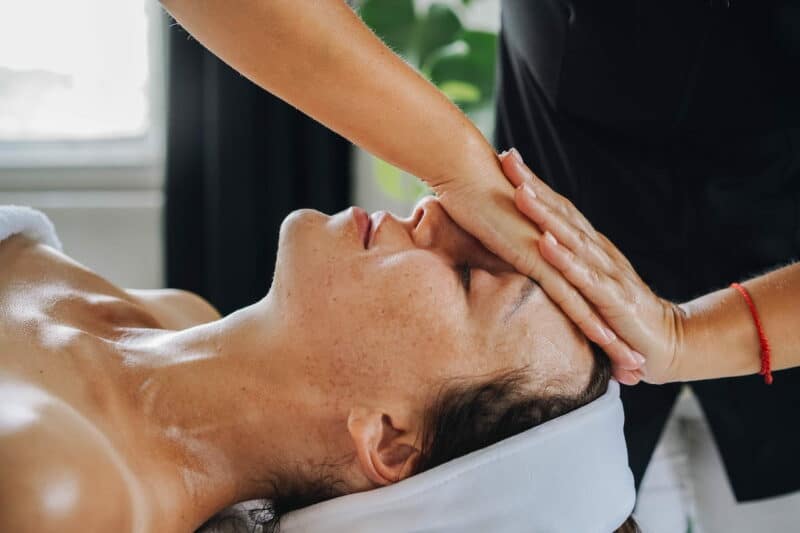 massage du visage bienfaits : une femme se fait masser le visage
