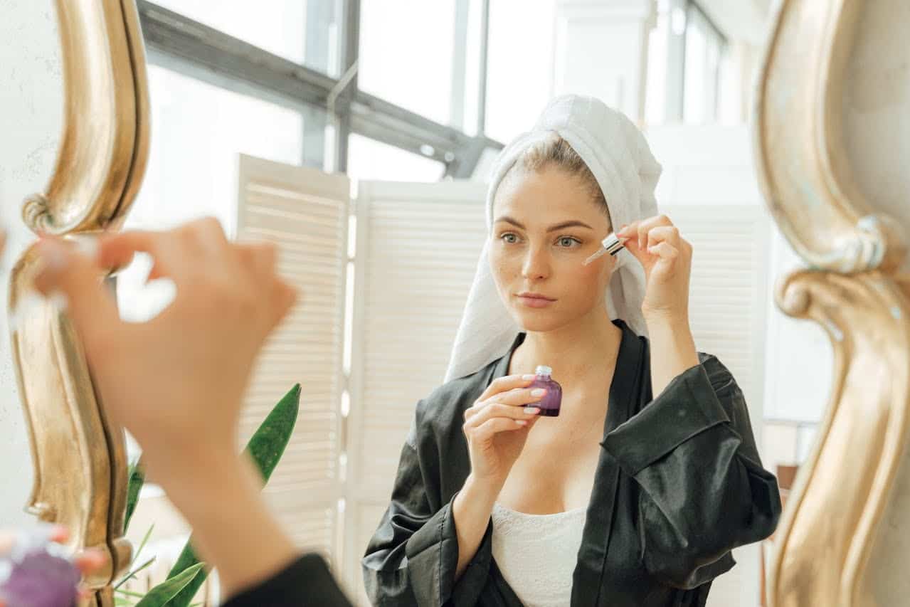 peau sensible en hiver : une femme prend soin de sa peau avec un sérum