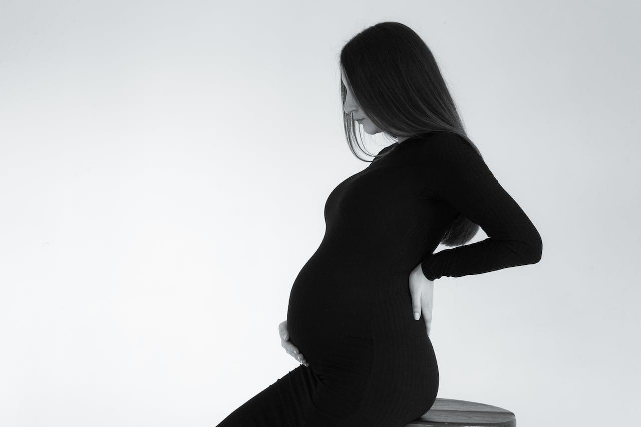 mal de dos femme enceinte : une femme enceinte se tenant le dos