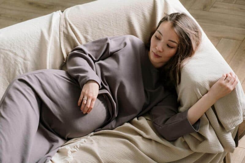 remède contre la fatigue : une femme enceinte est allongée sur un canapé