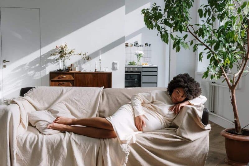 remède contre la fatigue : une femme enceinte est allongée sur un canapé