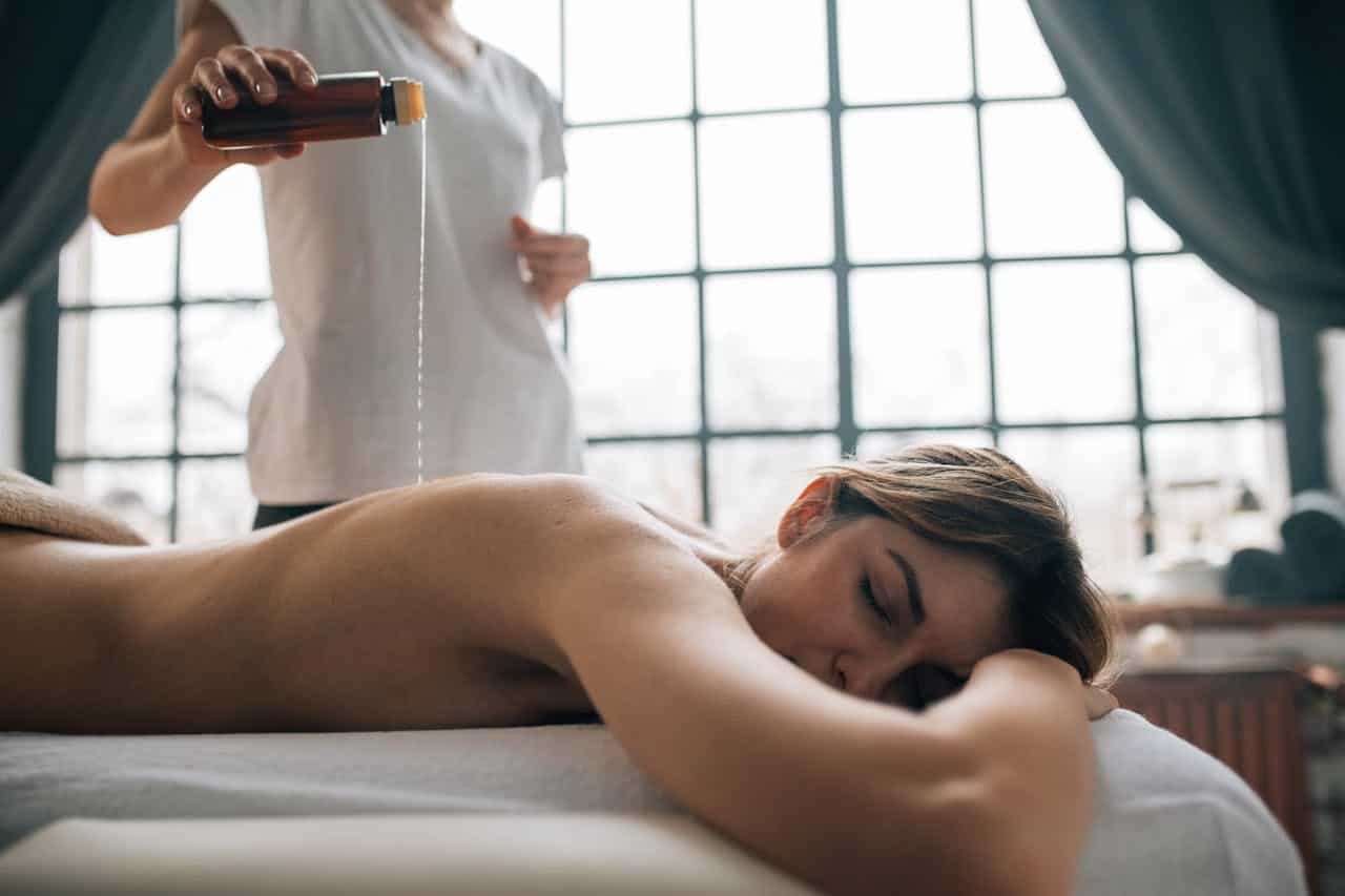 une femme allongée sur un tapis de massage reçoit un massage oriental