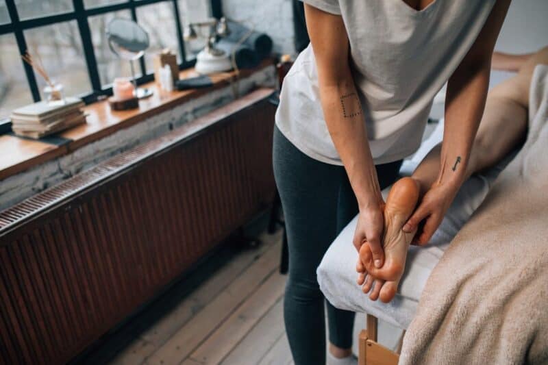 massage des pieds bienfaits : une femme se fait masser les pieds