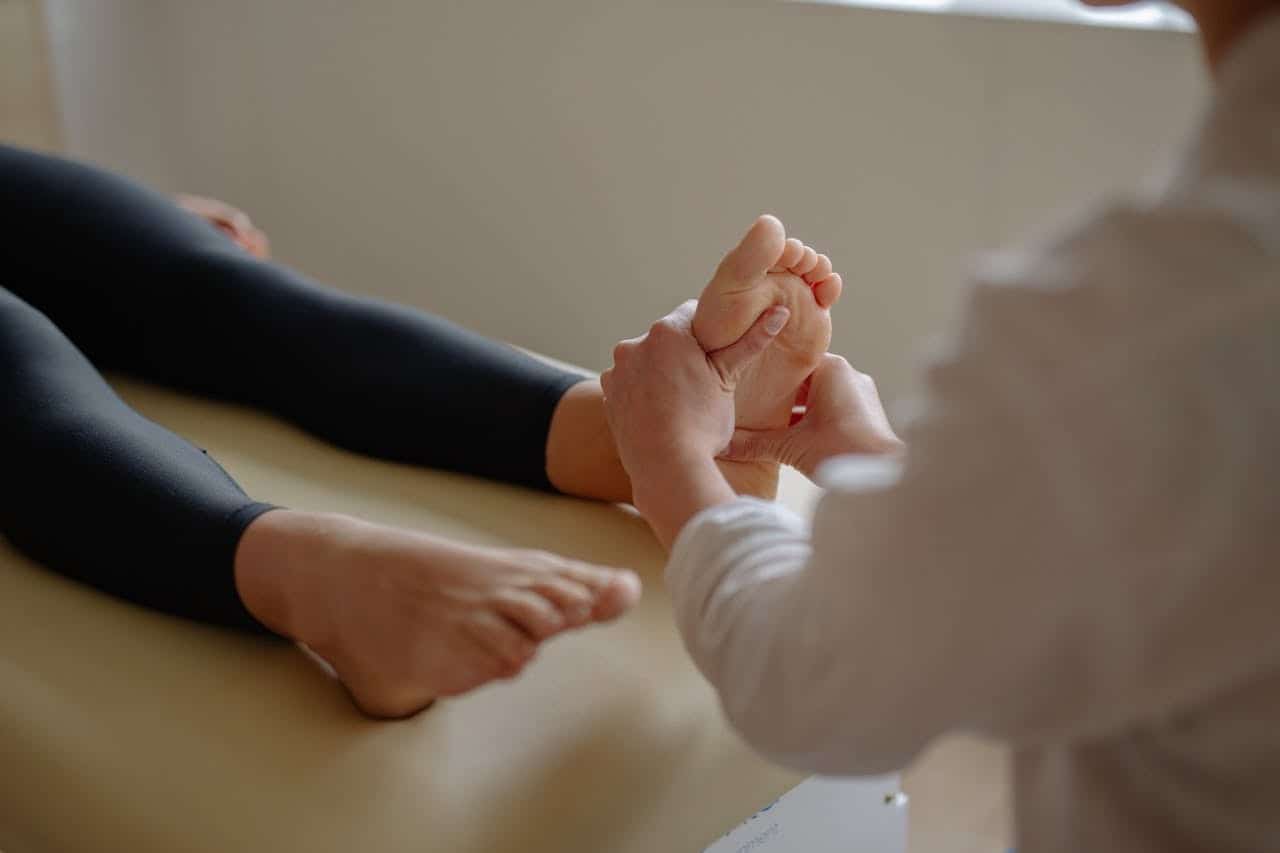 massage des pieds bienfaits : une femme se fait masser les pieds