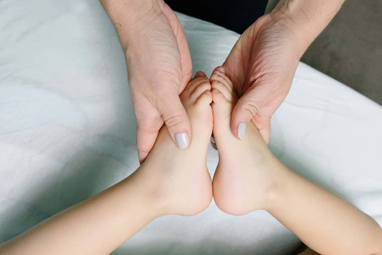Une personne réalise un massage bébé ciblé sur les pieds